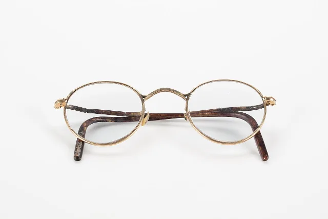 Paire de lunettes anciennes à monture dorée et branches en écaille